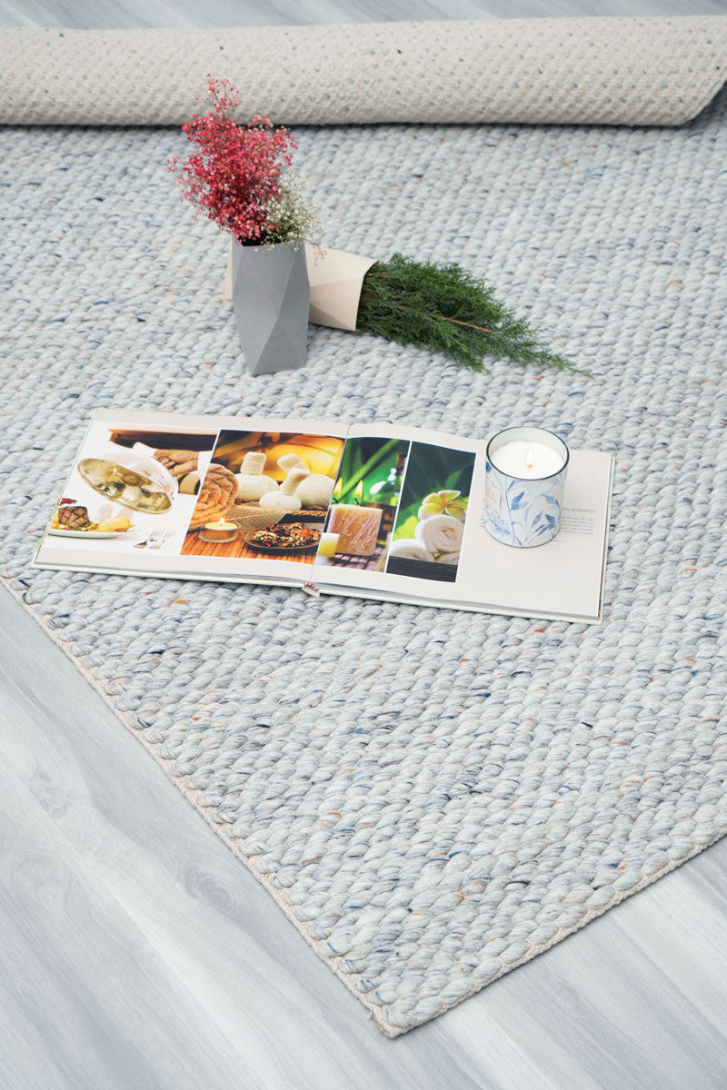 Coastal blue wool carpet styled in a bright living room setting