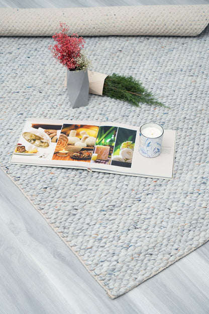 Coastal blue wool carpet styled in a bright living room setting